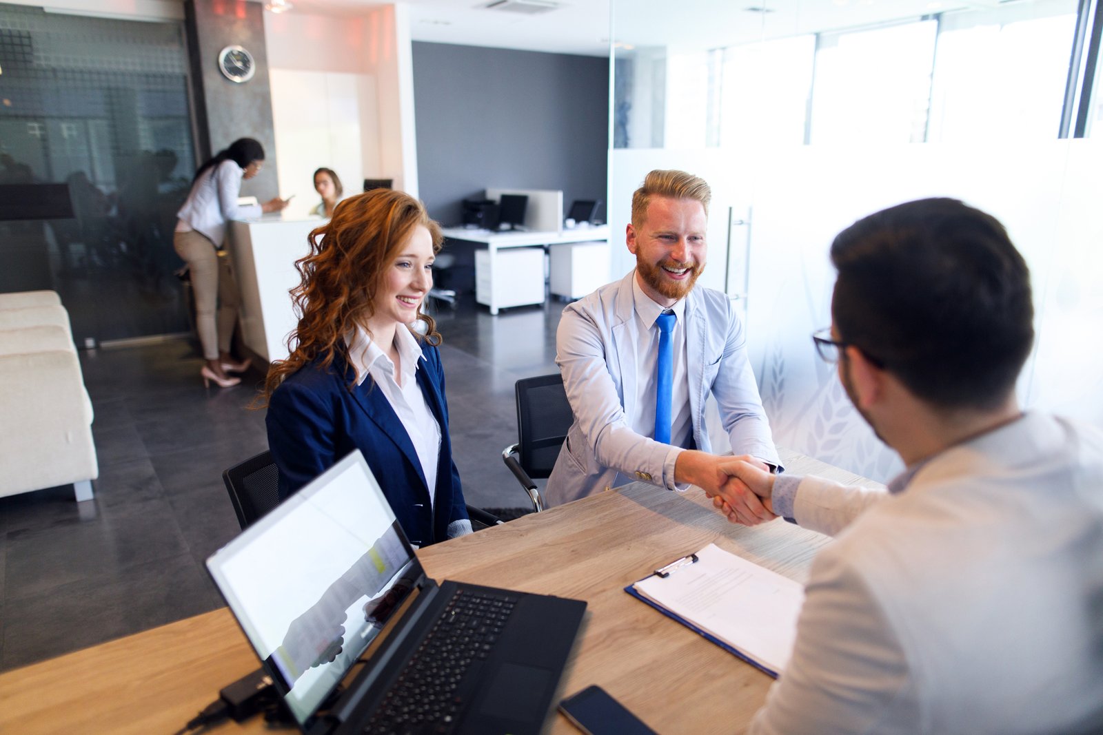 Couple talking to loan officer and shaking hands Couple talking to loan officer and shaking hands